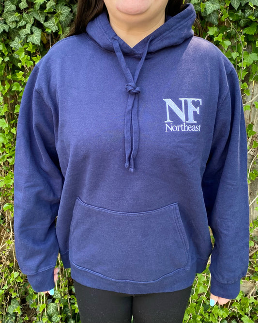 navy blue hoodie with front pocket on woman with NF Northeast logo embroidered on upper left chest