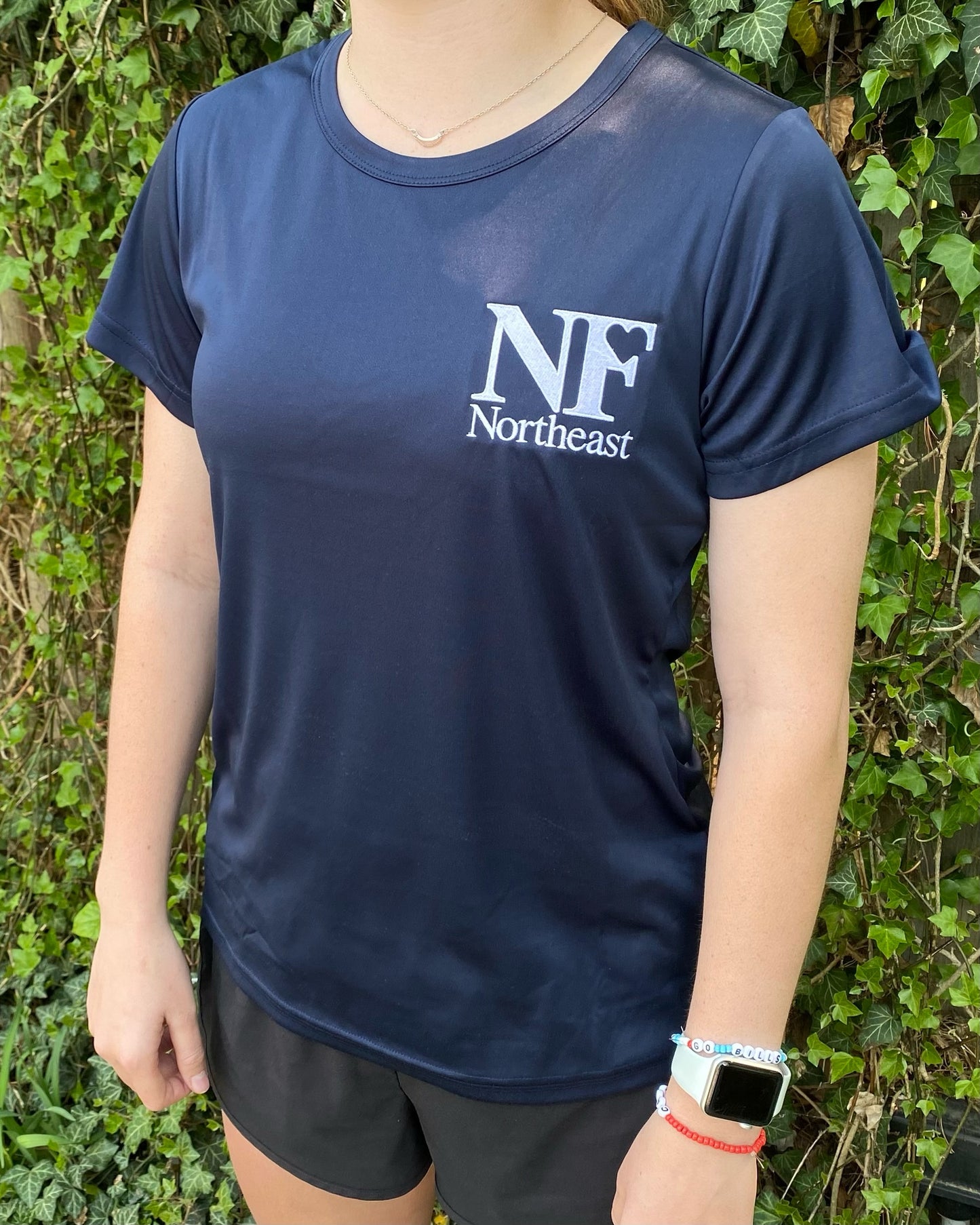 side view of navy dri-fit t-shirt with NF Northeast logo embroidered in white on left chest