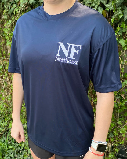 side view of navy dri-fit short sleeve shirt with NF Northeast logo embroidered in white on left chest
